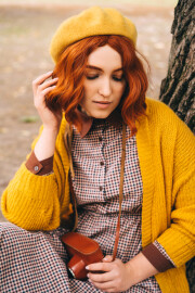 A,Beautiful,Red-haired,Woman,With,A,Curly,Hairstyle,Is,Sitting