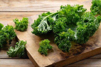 Cutting,Board,And,Kale,On,Wooden,Background.,Curly,Kale.,Close-up.