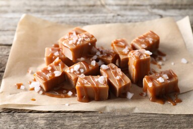 Yummy,Candies,With,Caramel,Sauce,And,Sea,Salt,On,Wooden