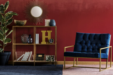 Golden,Metal,Rack,With,Books,And,Decor,Standing,In,Burgundy