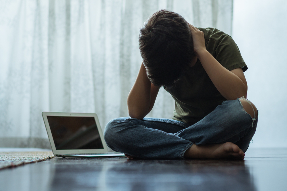 Cyberbullying,Concept.,Young,Asian,Preteen/teenage,Boy,Sit,Cross,Legged,Alone