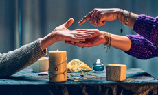 Fortune,Teller,Woman,Reading,Palm,Lines,Around,Candles,And,Other