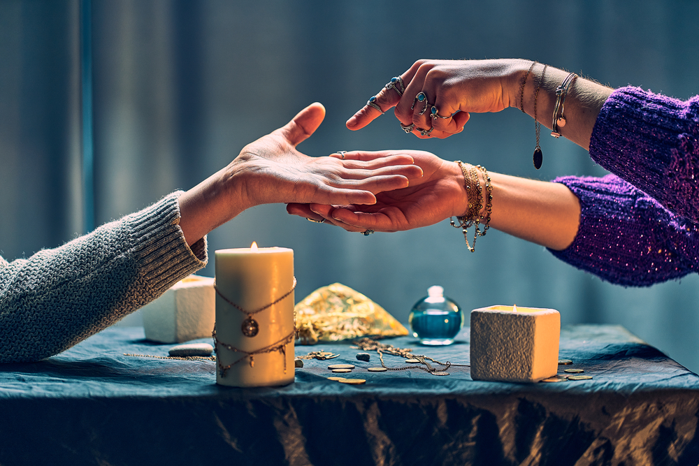 Fortune,Teller,Woman,Reading,Palm,Lines,Around,Candles,And,Other