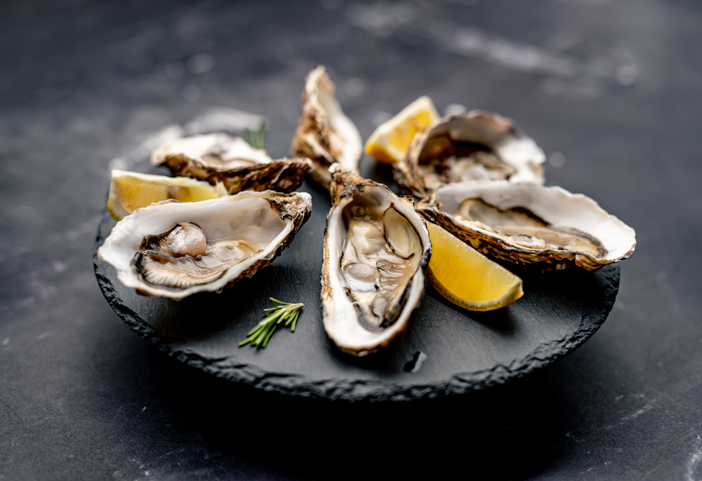 Oysters,With,Lemon,Served,On,Black,Round,Platter.,Luxury,Delicatessen