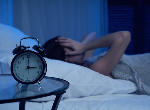 Unhappy,Woman,With,Insomnia,Lying,On,Bed,Next,To,Alarm