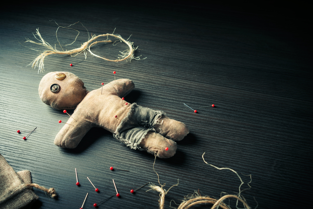 Voodoo,Doll,On,A,Wooden,Background,With,Dramatic,Lighting