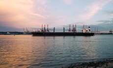 Cargo ship parked at the harbor on a sunny day during sunset
