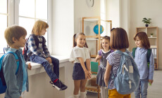Bunch,Of,Kids,With,School,Bags,Standing,In,The,Classroom