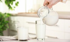 Woman,Pouring,Fresh,Milk,From,Jug,Into,Glass,At,Light