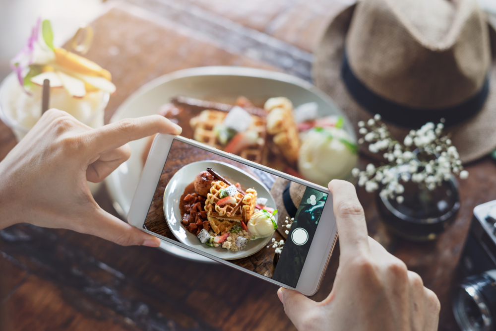 Young,Woman,Taking,Photo,Of,Food,With,Smart,Phone,In