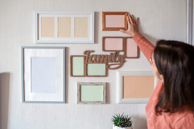 Girl,Hanging,Frame,On,White,Wall,With,Set,Of,Different