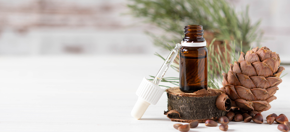 Glass,Bottle,With,Oil,,Pipette,And,Cedar,Cone,On,Light