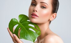 Young,Beautiful,Woman,With,Green,Leave,Near,Face,And,Body.