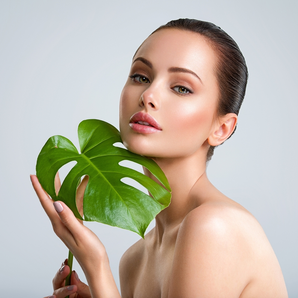 Young,Beautiful,Woman,With,Green,Leave,Near,Face,And,Body.