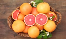 Wicker,Basket,With,Fresh,Grapefruits,And,Green,Leaves,On,Wooden