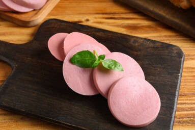 Board,With,Slices,Of,Tasty,Boiled,Sausage,And,Basil,On