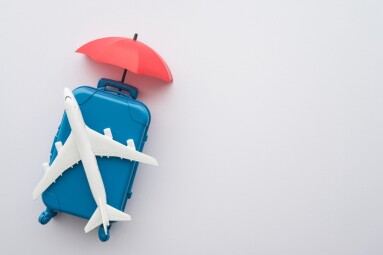 Travel,Insurance,Business,Concept.,Red,Umbrella,Cover,Airplane,And,Suitcases