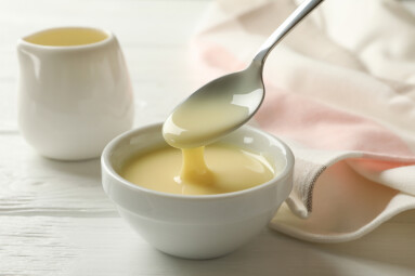Kitchen,Towel,And,Bowls,With,Condensed,Milk,On,Wooden,Background