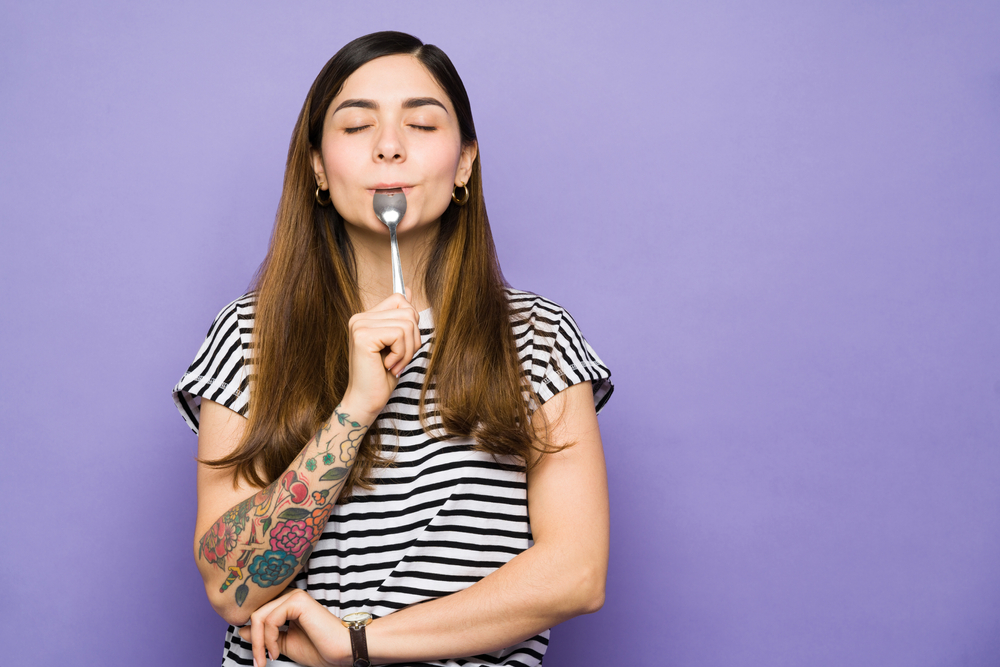 Hungry,Young,Woman,With,Her,Eyes,Closed,Enjoying,A,Spoonful