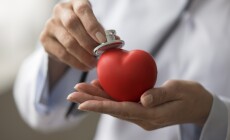 Hands,Of,Female,Cardiologist,Applying,Stethoscope,To,Red,Heart,Shaped