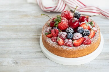 Whole,Fruit,Cake,Decorated,With,Sliced,Fresh,Strawberries,,Raspberries,And