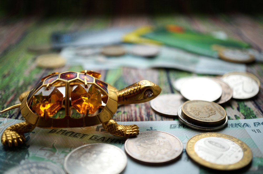 A,Turtle,Statuette,With,Coins,On,The,Table.,A,Financial