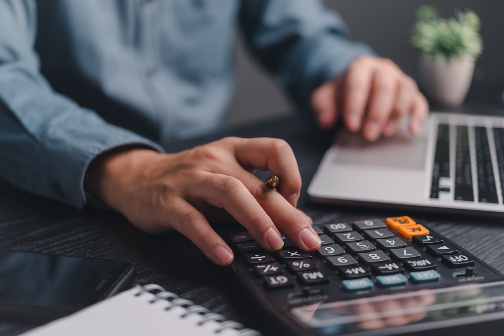 Businessman,Using,Calculator,Bookkeeping,Payroll,And,Budget,Tax.,Business,Document