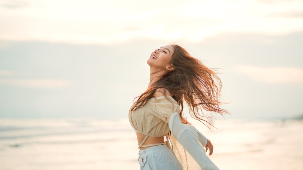 Side,View,Of,Young,Asian,Woman,With,Freedom,On,The