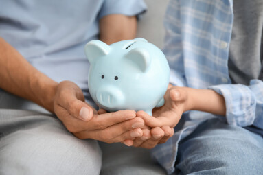 Family,With,Piggy,Bank,At,Home,,Closeup