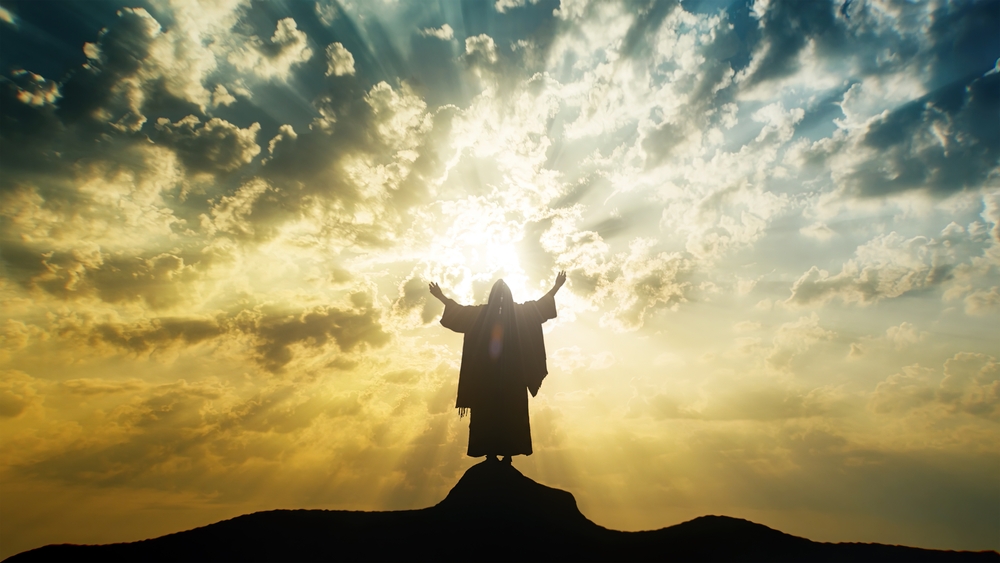 Silhouette,Of,Jesus,Praying,With,Raised,Hands,On,A,Mount