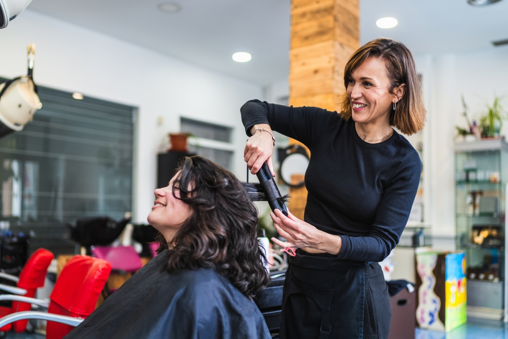 A,Hairdresser,Uses,A,Curling,Iron,To,Curl,A,Client's