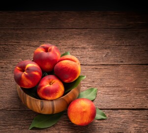 Fresh,Peach,Fruit,In,Wooden,Bowl,On,Wooden,Background,,Yellow