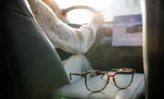 Eyeglasses,On,Car,Seat,With,Driver,In,Background,And,Sunlight