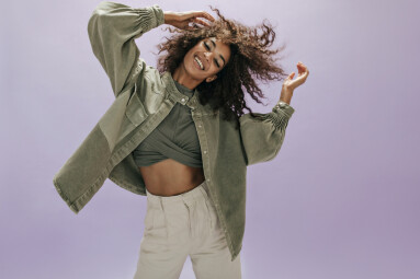 Positive,Modern,Lady,With,Curly,Hair,In,Top,,Wide,Olive