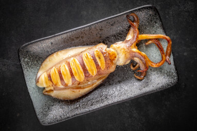 Fried,Whole,Squid,In,Ceramic,Plate,On,Dark,Tone,Texture