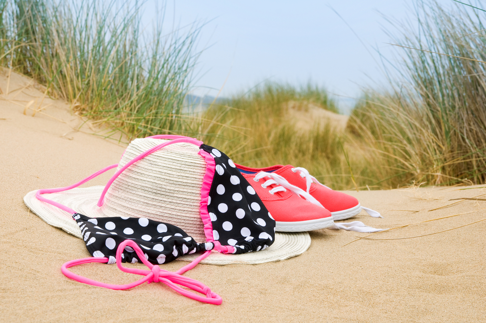 Bikini,,Sun,Hat,And,Shoes,In,Sand,Dunes,On,Beach