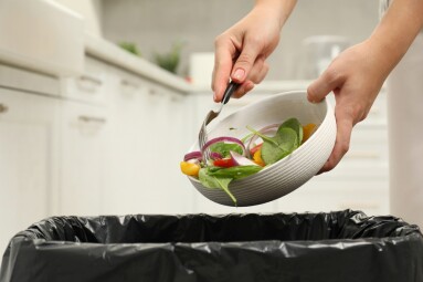 Woman,Throwing,Vegetable,Salad,Into,Bin,Indoors,,Closeup