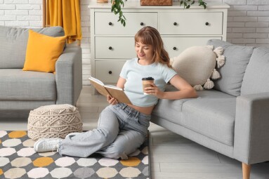 Beautiful,Young,Woman,With,Coffee,Reading,Book,On,Carpet,Near