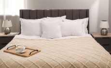 Many,Soft,White,Pillows,And,Knitted,Blanket,On,Bed,Indoors