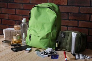 Survival,Kit.,Different,Emergency,Supplies,On,Wooden,Table,Near,Brick