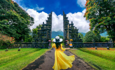 Woman,Walking,At,Big,Entrance,Gate,,Bali,In,Indonesia.