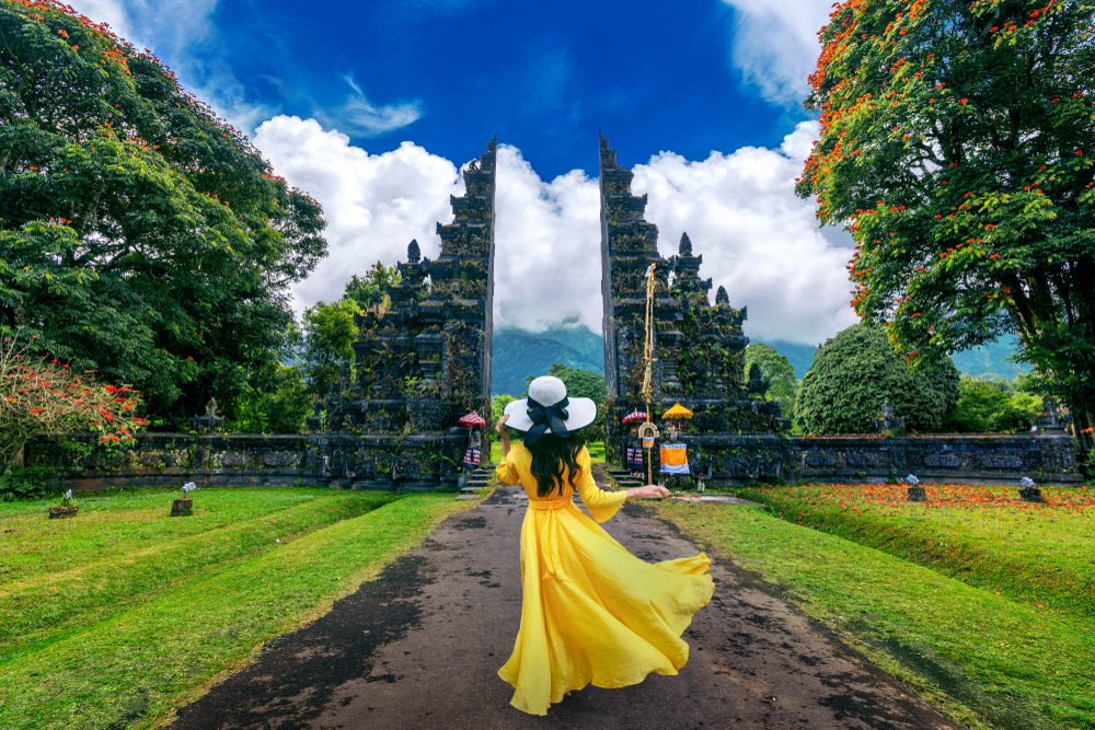 Woman,Walking,At,Big,Entrance,Gate,,Bali,In,Indonesia.