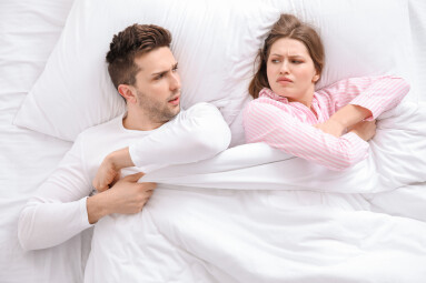 Young,Couple,Fighting,For,Blanket,In,Bed