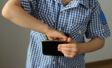 Kid,Holds,A,Wallet,And,Takes,Out,With,His,Hand,