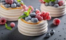 Sweet,Mini,Pavlova,Dessert,With,Frozen,Fruit,And,Whipped,Cream.