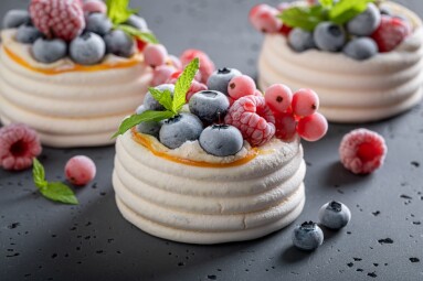 Sweet,Mini,Pavlova,Dessert,With,Frozen,Fruit,And,Whipped,Cream.
