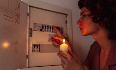 Young,Woman,With,Candles,In,Complete,Darkness,Examines,Fuse,Box