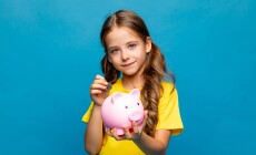 Happy,Little,Girl,In,Yellow,T-shirt,Holding,Pink,Piggy,Bank