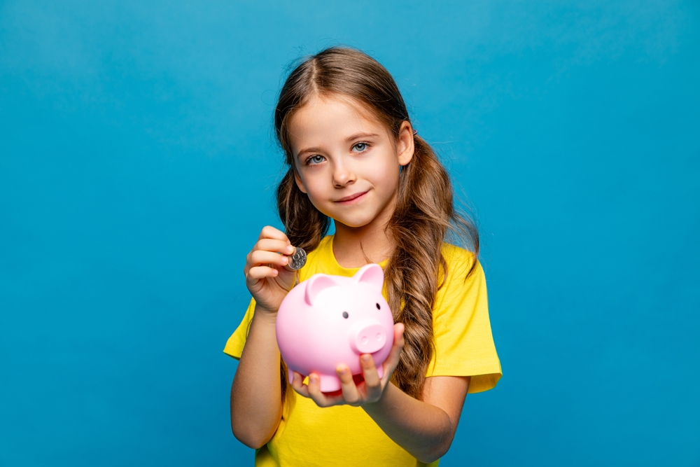 Happy,Little,Girl,In,Yellow,T-shirt,Holding,Pink,Piggy,Bank