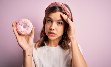 Young,Blonde,Girl,Eating,Sweet,Bakery,Sugar,Doughnut,Over,Pink